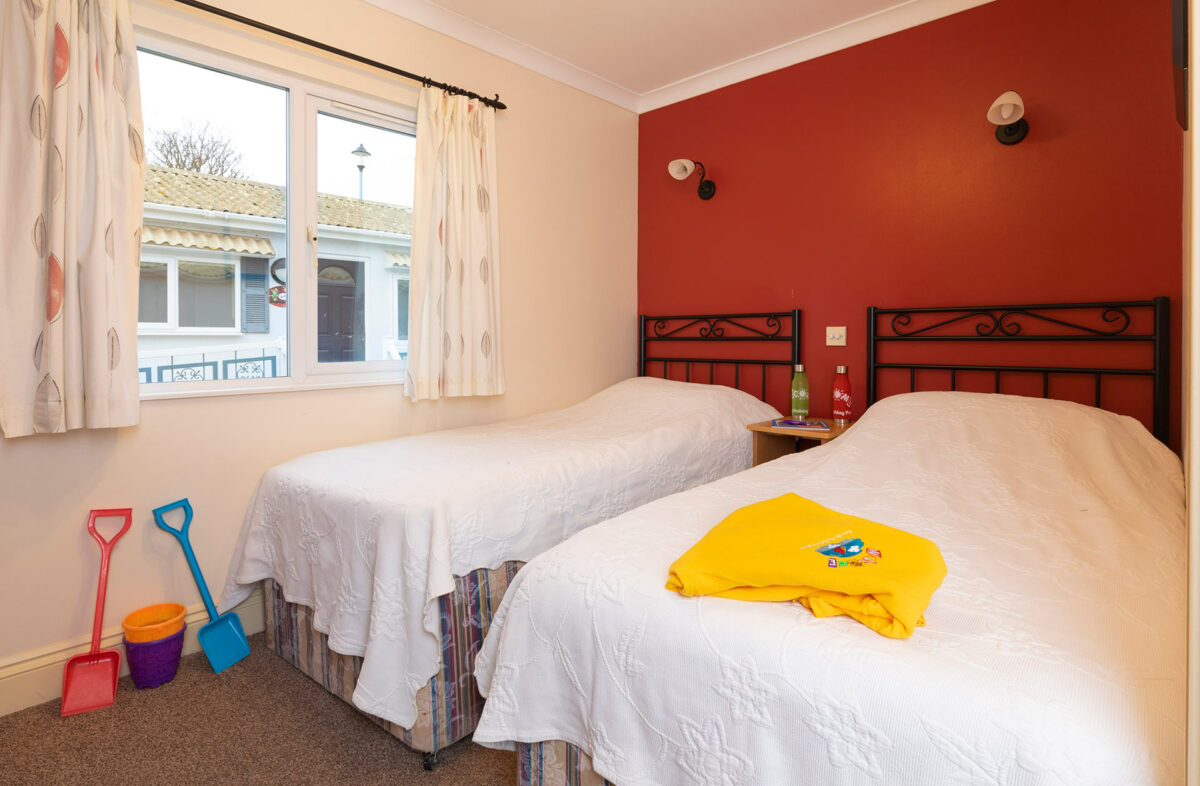 Twin bedroom with hoodie on the bed in the Casamigo lodge at the Welcome Family Holiday Park