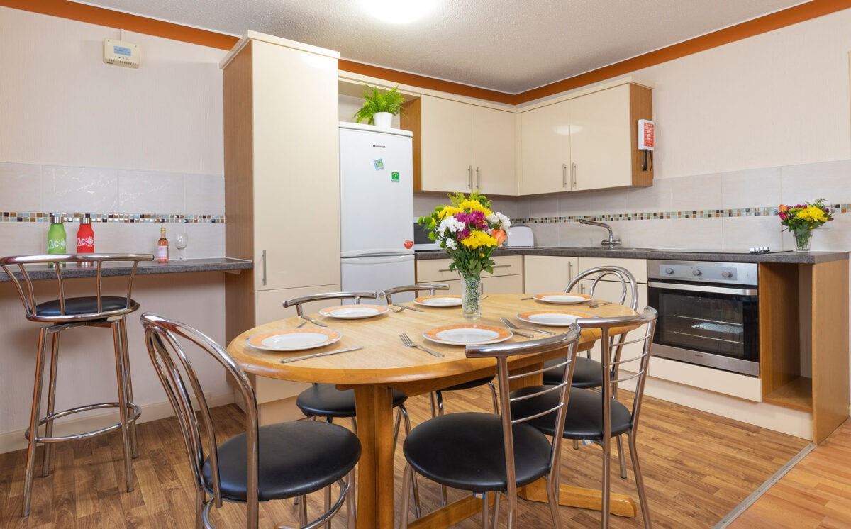 Dining table ready for dinner in Starsurfer bungalow at Welcome Family Holiday Park