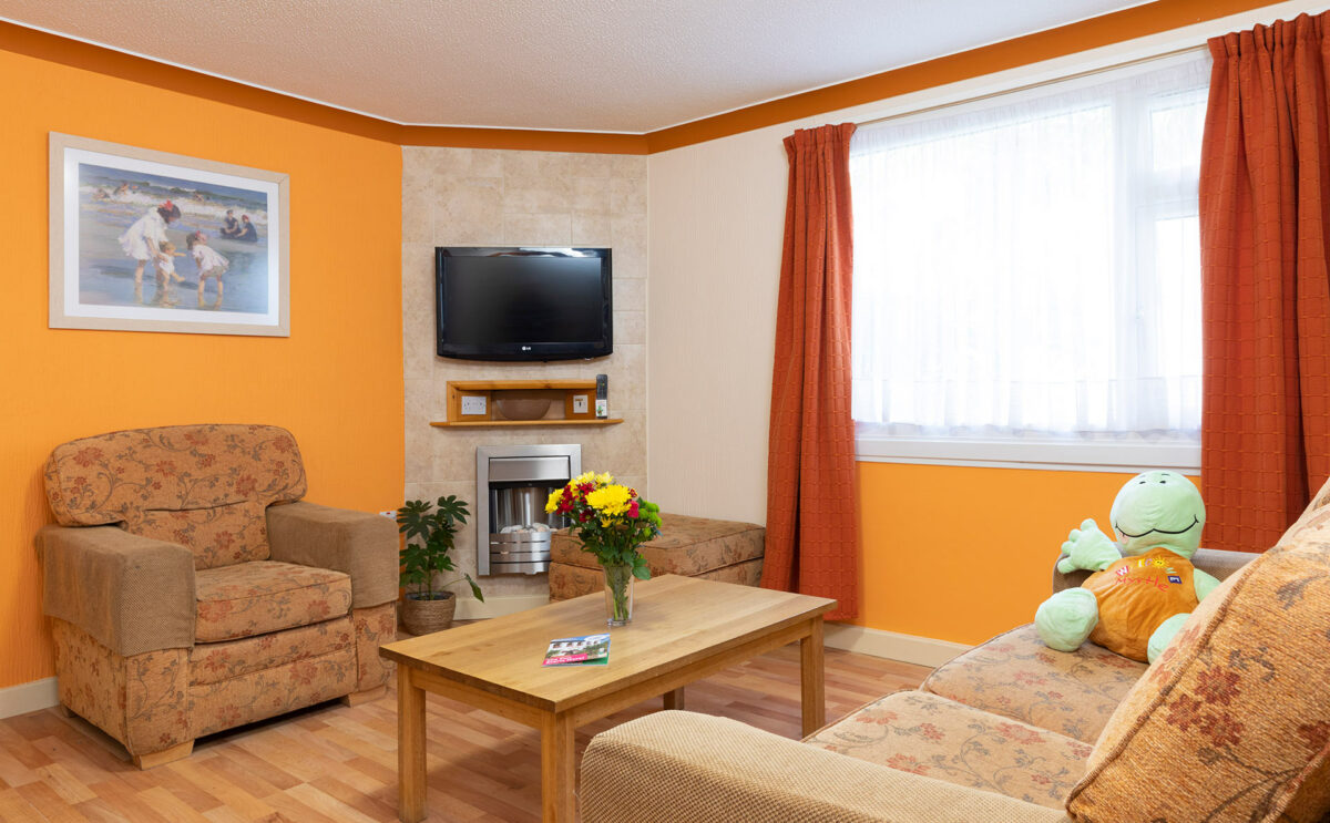 Lounge area with TV in Starsurfer bungalow at Welcome Family Holiday Park