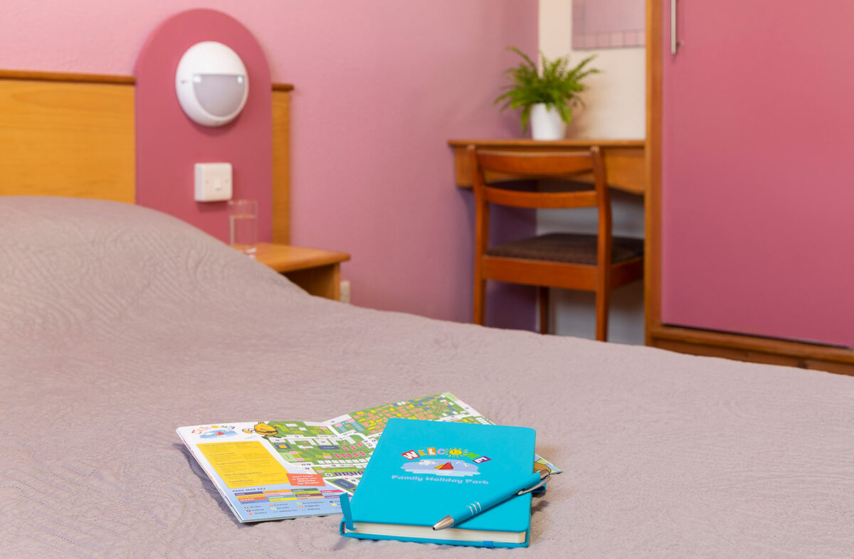 Notepad and pen in the master bedroom in the Wavesurfer bungalow at Welcome Family Holiday Park