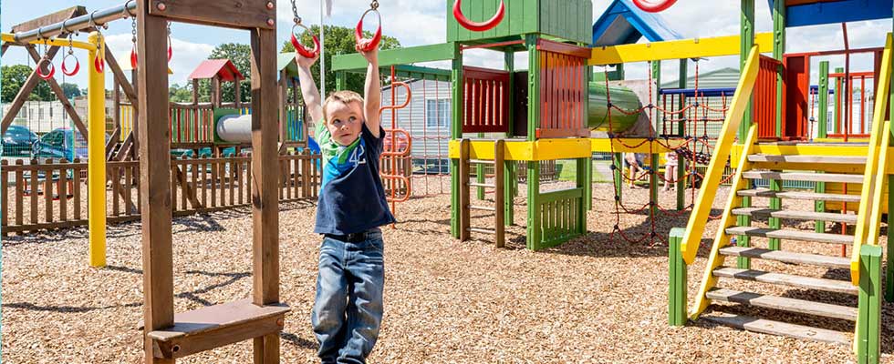 Boy swinging in fun park at Welcome Family Holiday Park