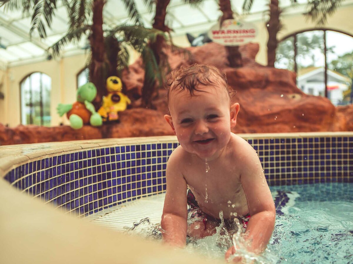 Cute toddler playing in swimming pool