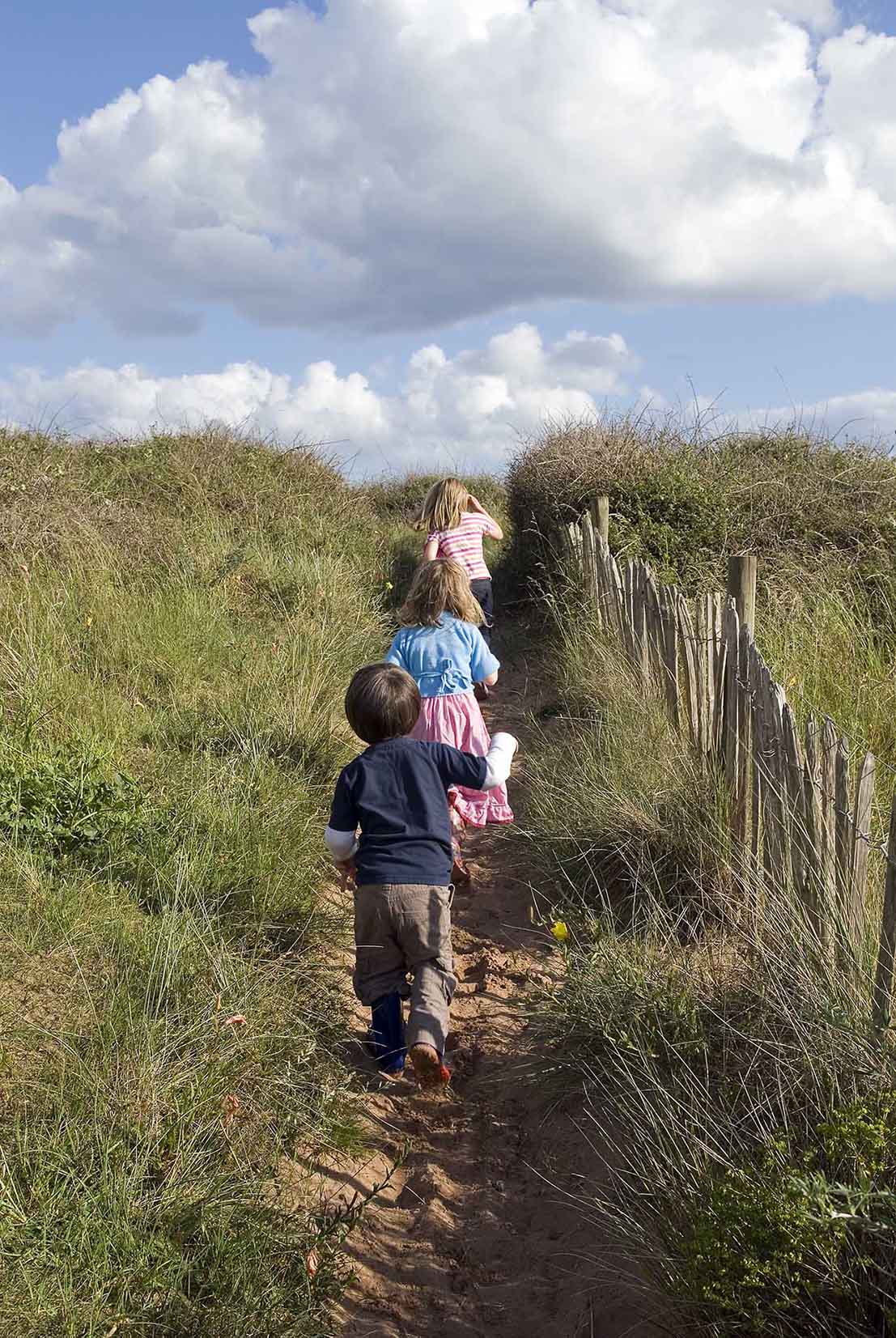 Children Walking along sandy path at Dawlish Warren