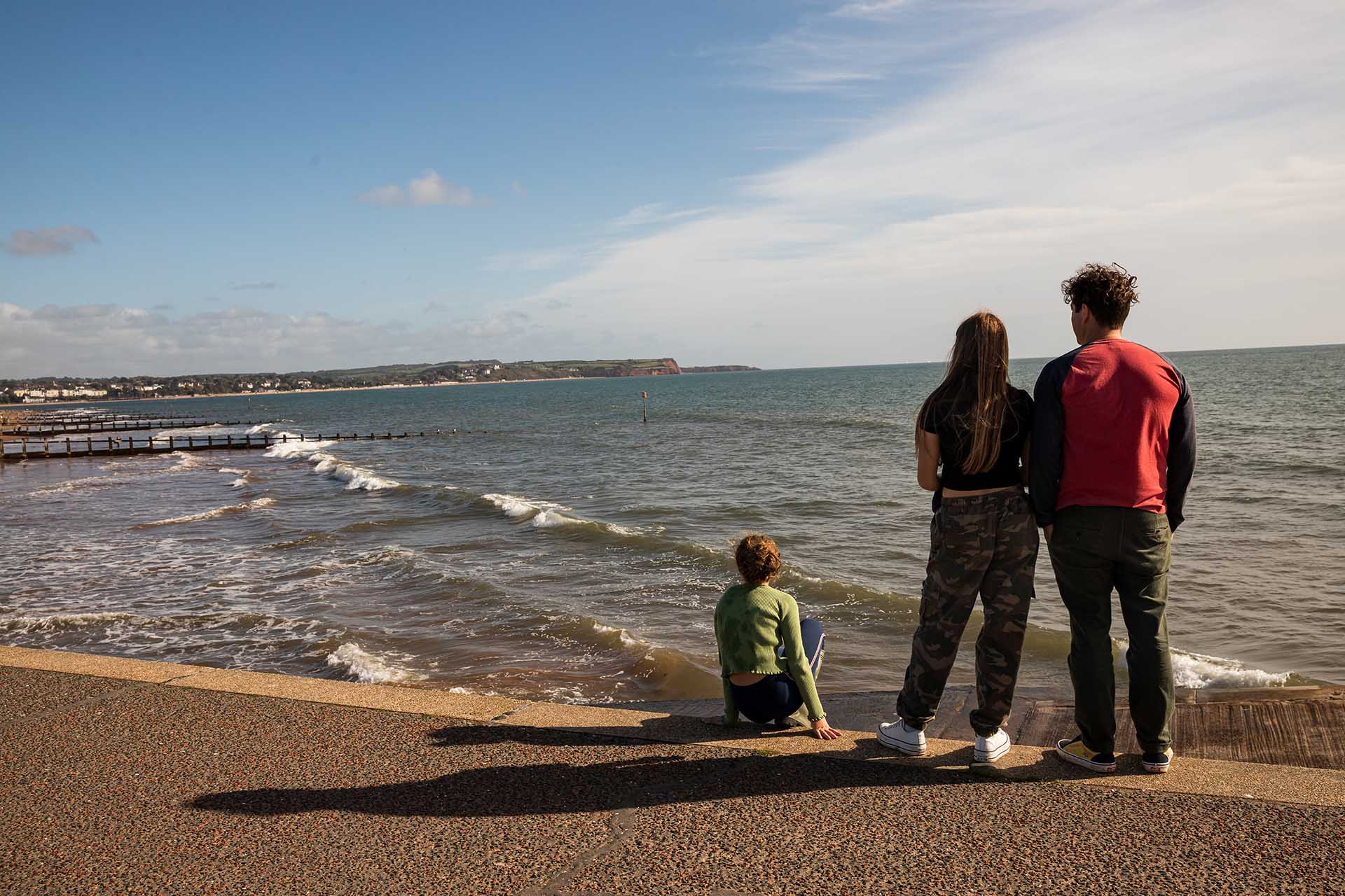 Dad and girls looking out to sea at Dawlish Warren