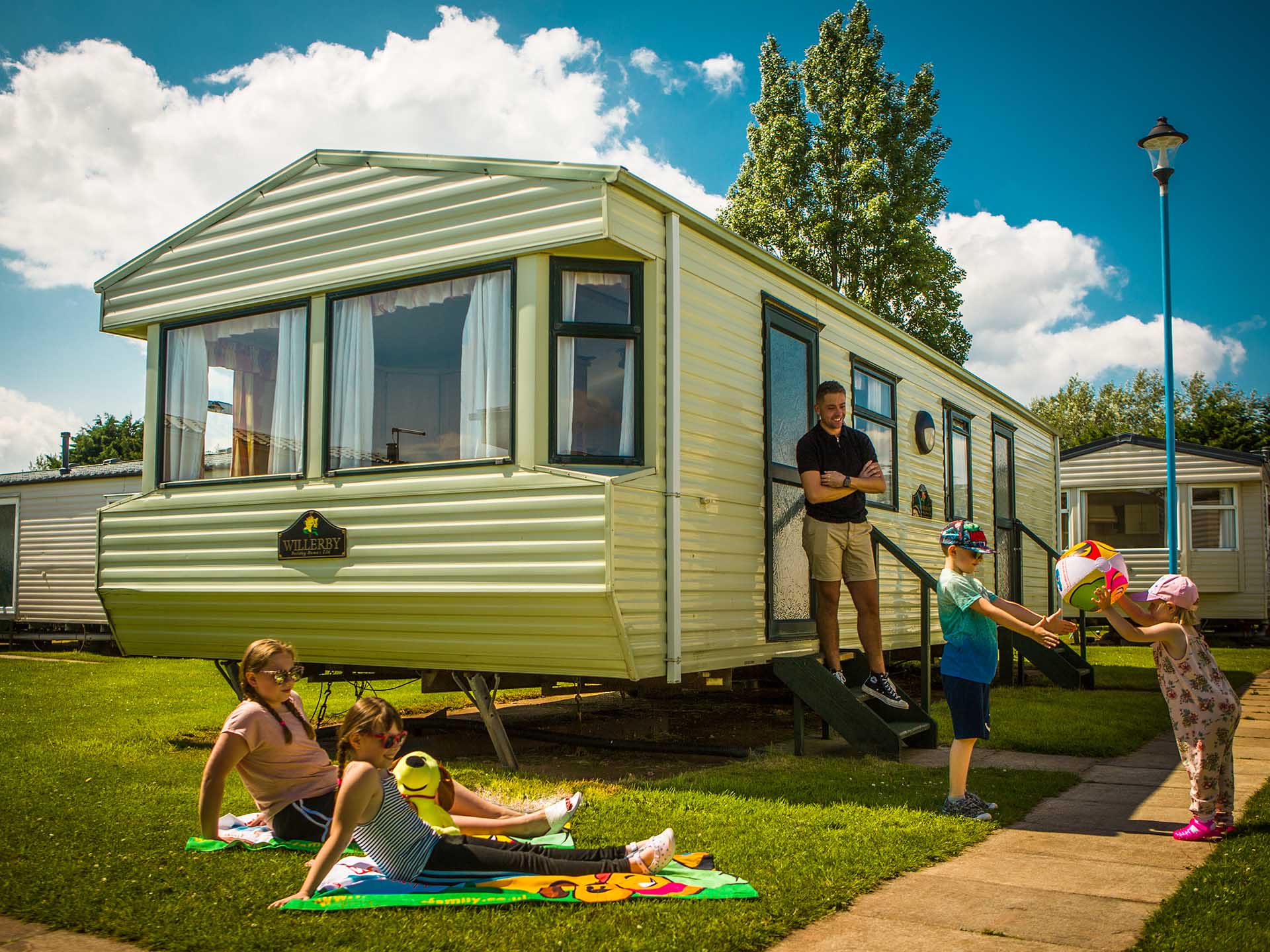 Family enjoying sunshine outside Classic caravan