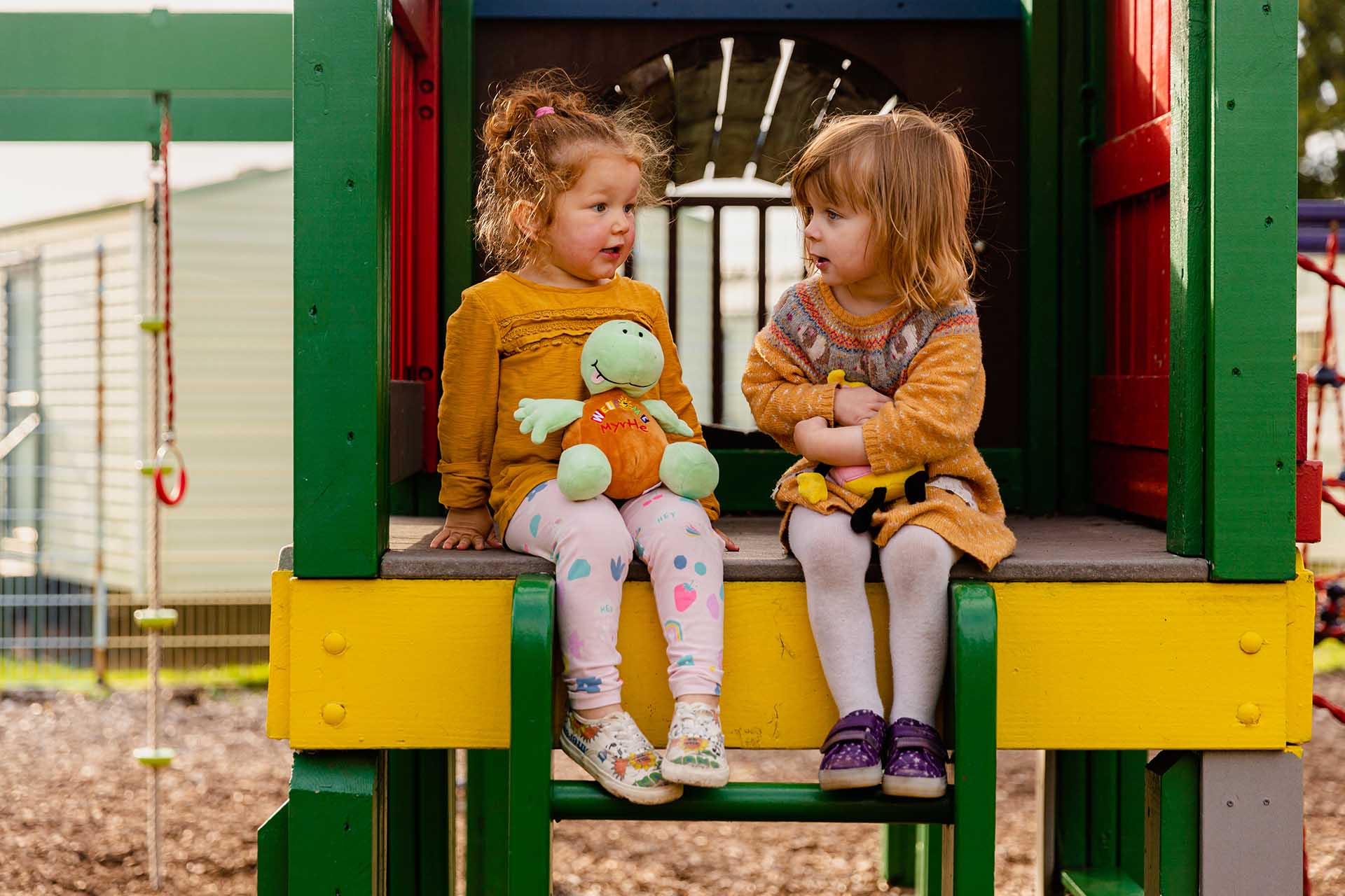 Little girls sitting and chatting in Welcome playground