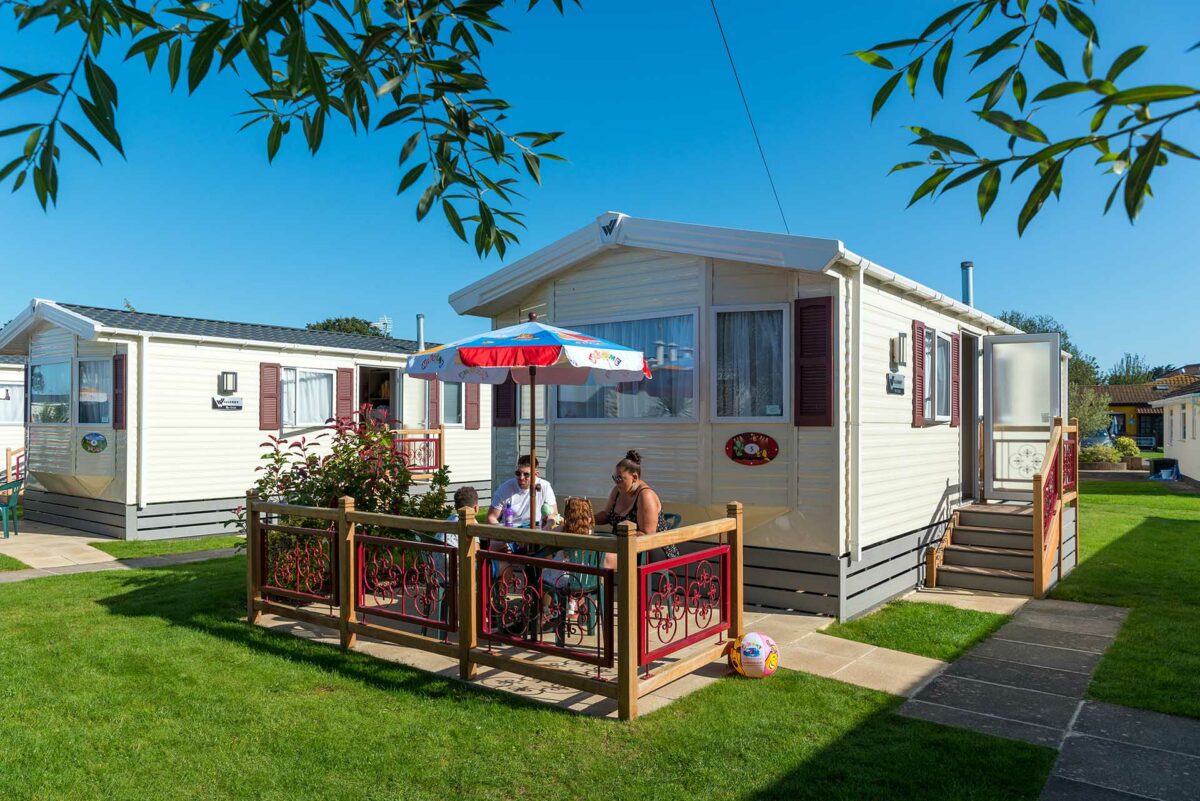 Family sitting outside their premier holiday caravan