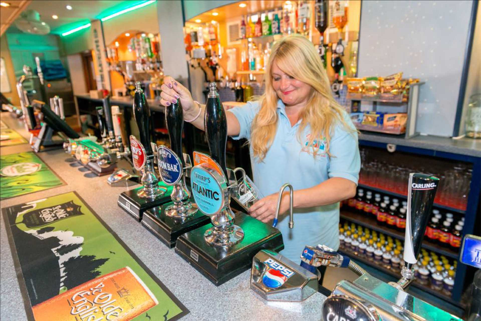 Welcome Club bar staff pulling a pint