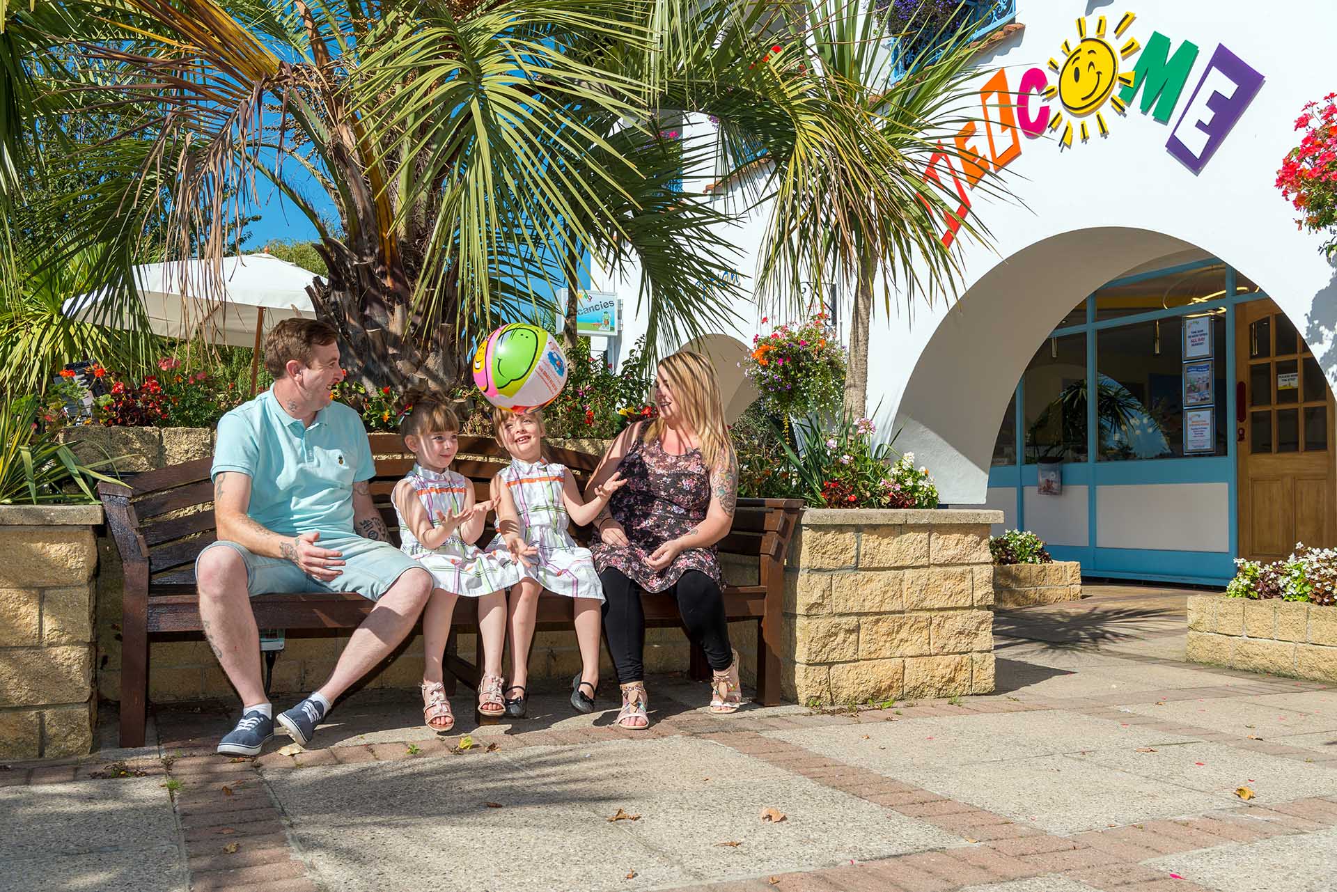 Family sitting outside Welcome reception under palm tree